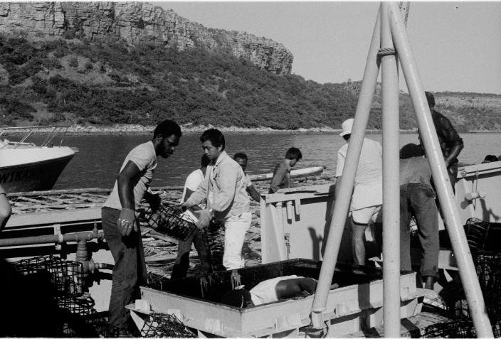 Two men carrying a crate. 